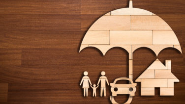 Tabletop wood puzzle silhouettes a family, car, and house under an umbrella